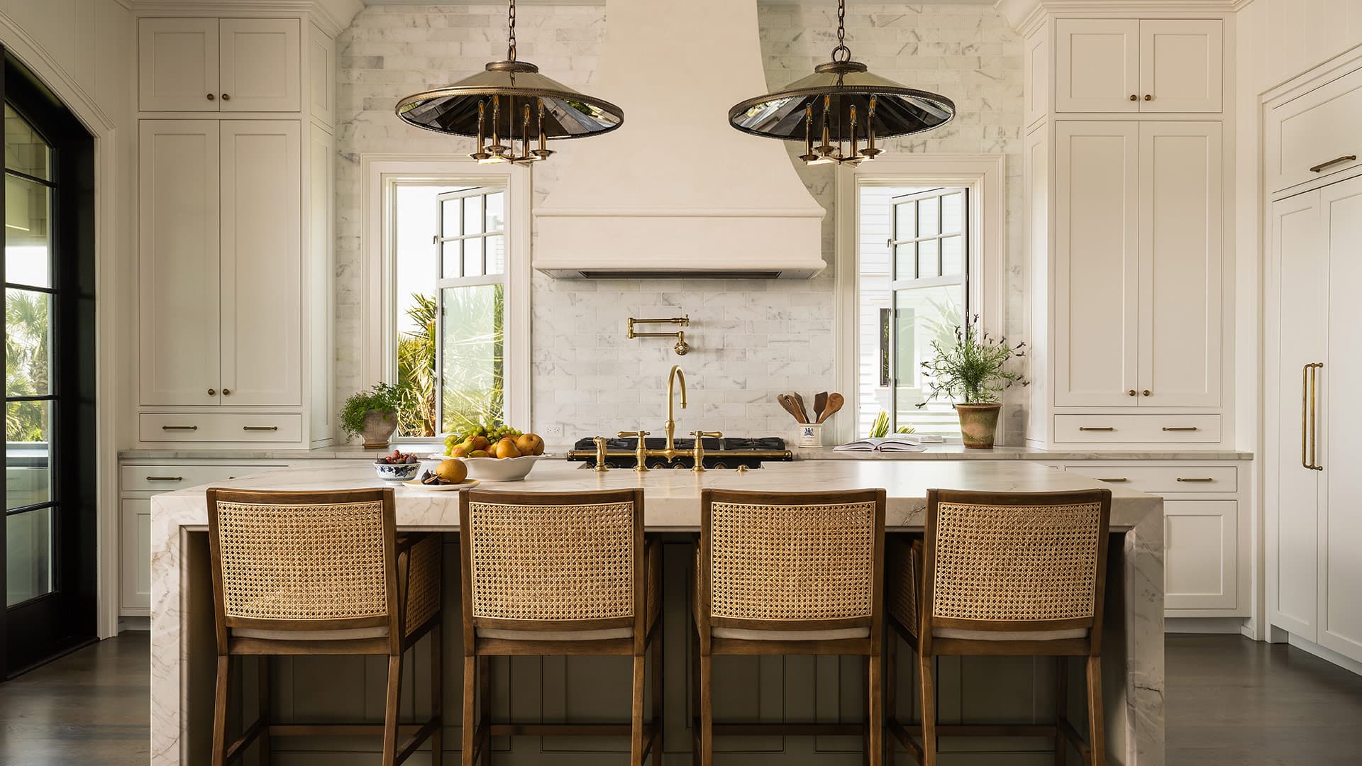 Dining room with a round wooden table, built-in glass cabinets, framed art, and a large pendant light.